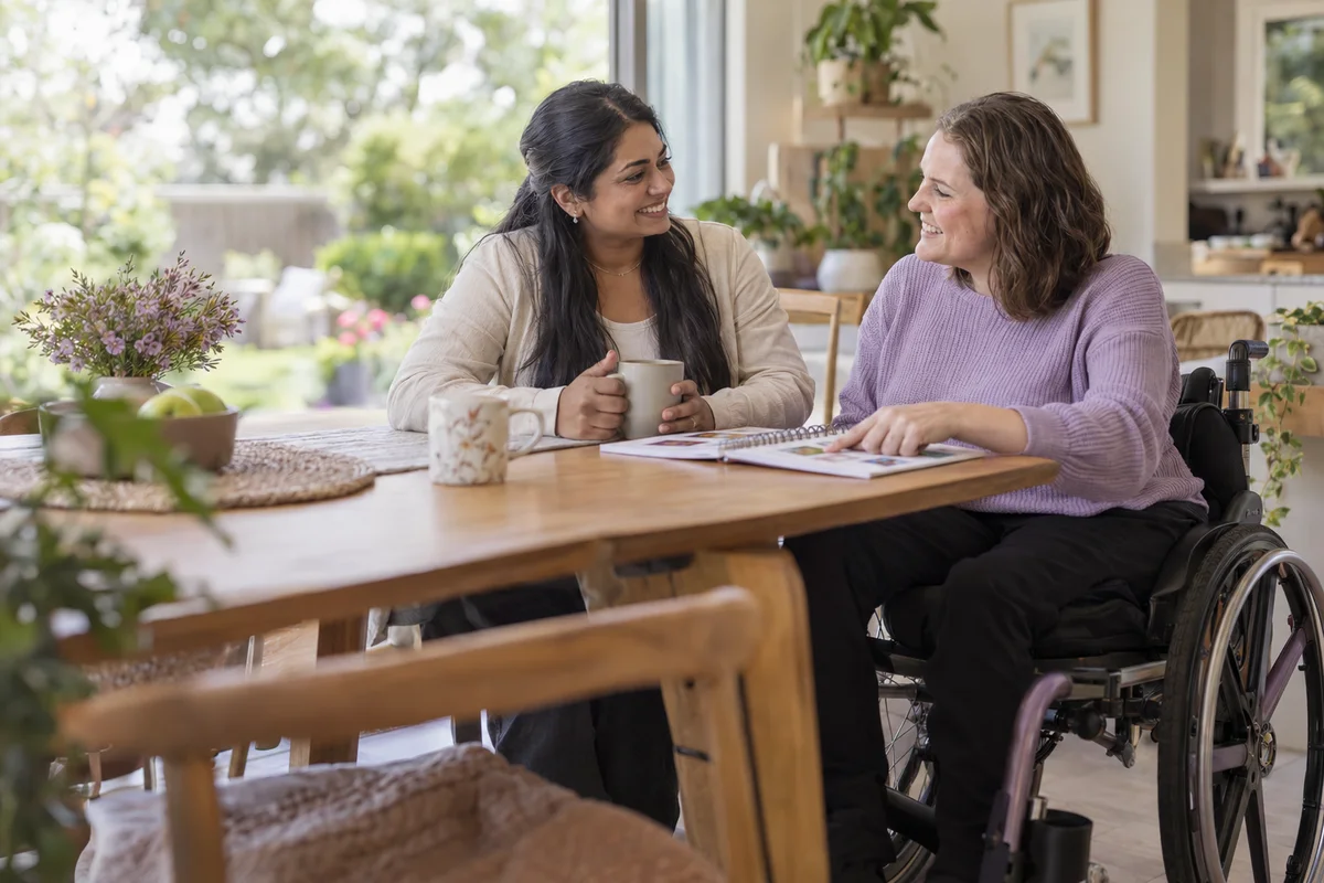 Illustrative editorial photo of a wheelchair user choosing an activity while a support person listens