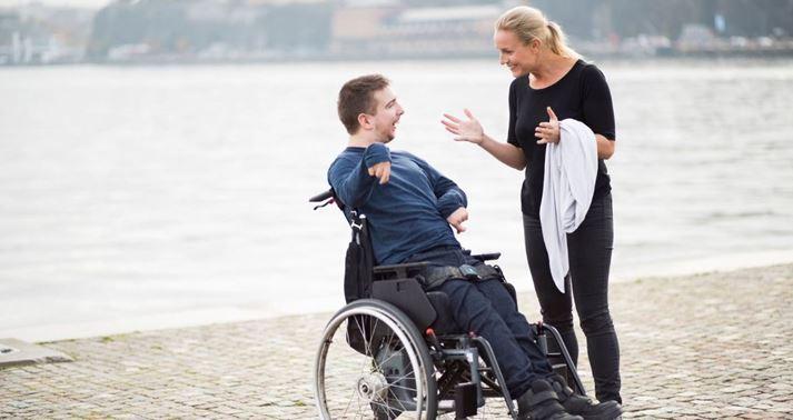A wheelchair user and support person enjoying time outdoors