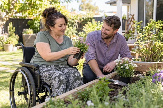 Illustrative photo of a wheelchair user and support person in a garden